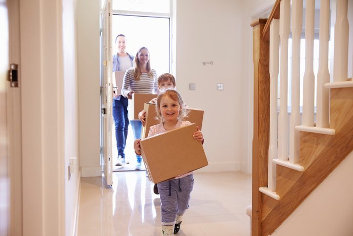 family walking into home with moving boxes