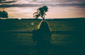 woman in the sunset looking into field