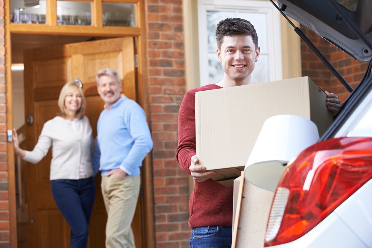 college kid moving out of parents with moving box